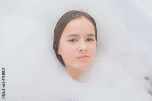 Beauty, spa, personal care. Young woman relaxes in the bath with foam