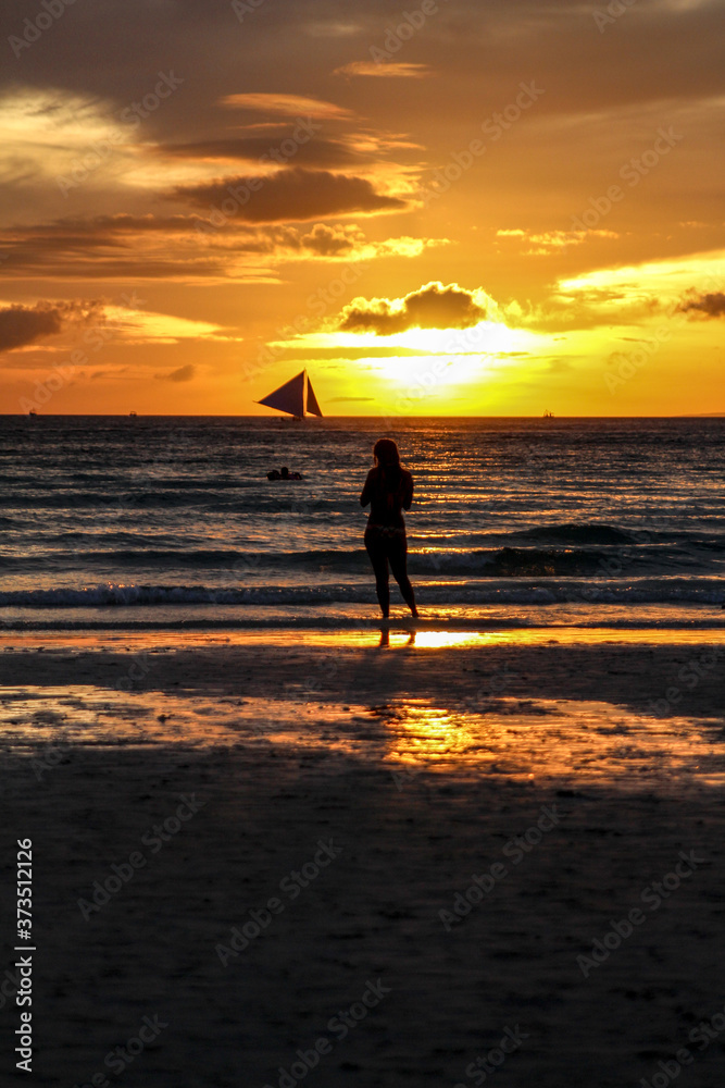 sailboat silhouette at sunset on the beach