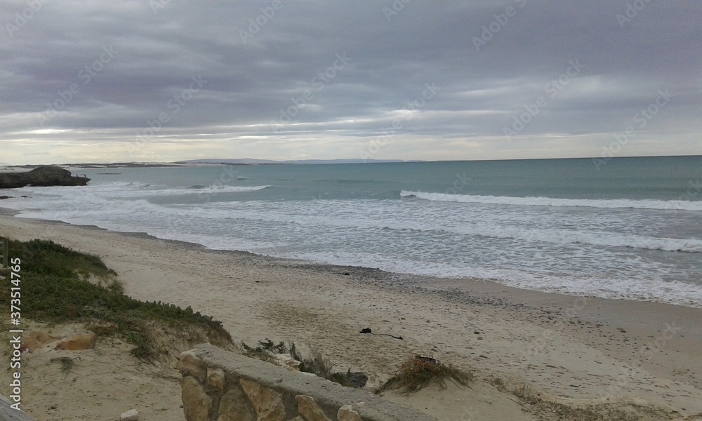The beautiful backdrop of the sea, sandy shores scattered with rocks layered into the skies of grey in South Africa The beautiful backdrop of the sea, sandy shores scattered with rocks layered into the skies of grey in South Africa
