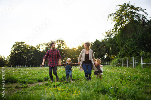 Portrait of family with small children walking on farm, resting.