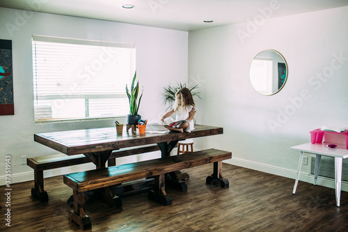 young girl sitting on table reading alone photo