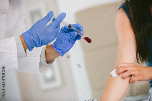 A shallow focus shot of a nurse drawing blood from the arm of a female patient
