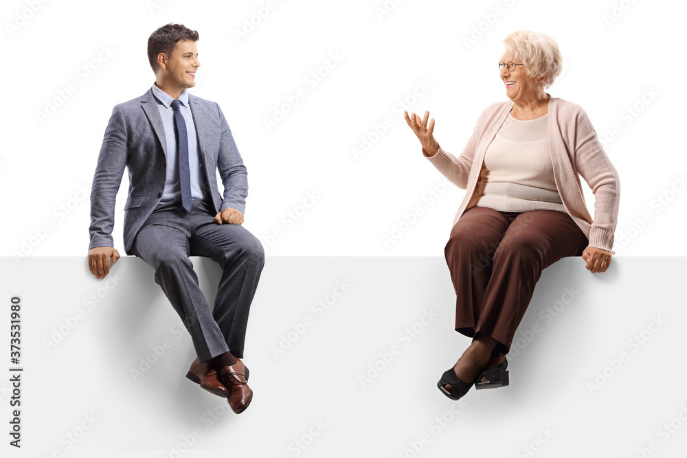 Elderly woman sitting on a blank panel and talking to a handsome young man Elderly woman sitting on a blank panel and talking to a handsome young man