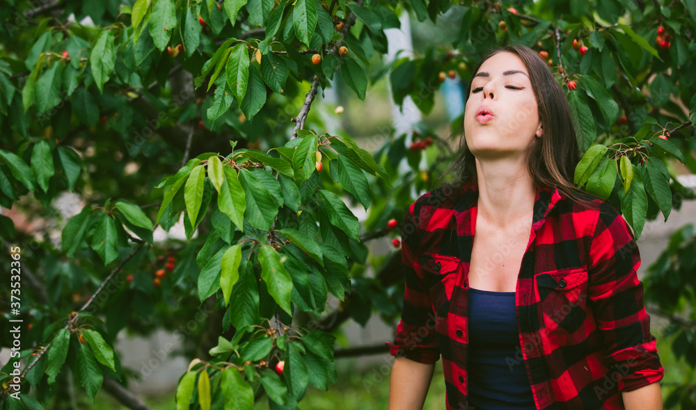 Beautiful young woman working in cherry garden