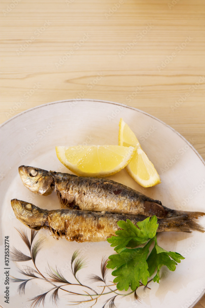 grilled sardines with lemon and parsley on the plate