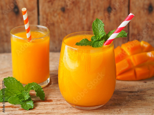 Mango smoothie topping with mint leaves for a summer drink and healthy food concept.