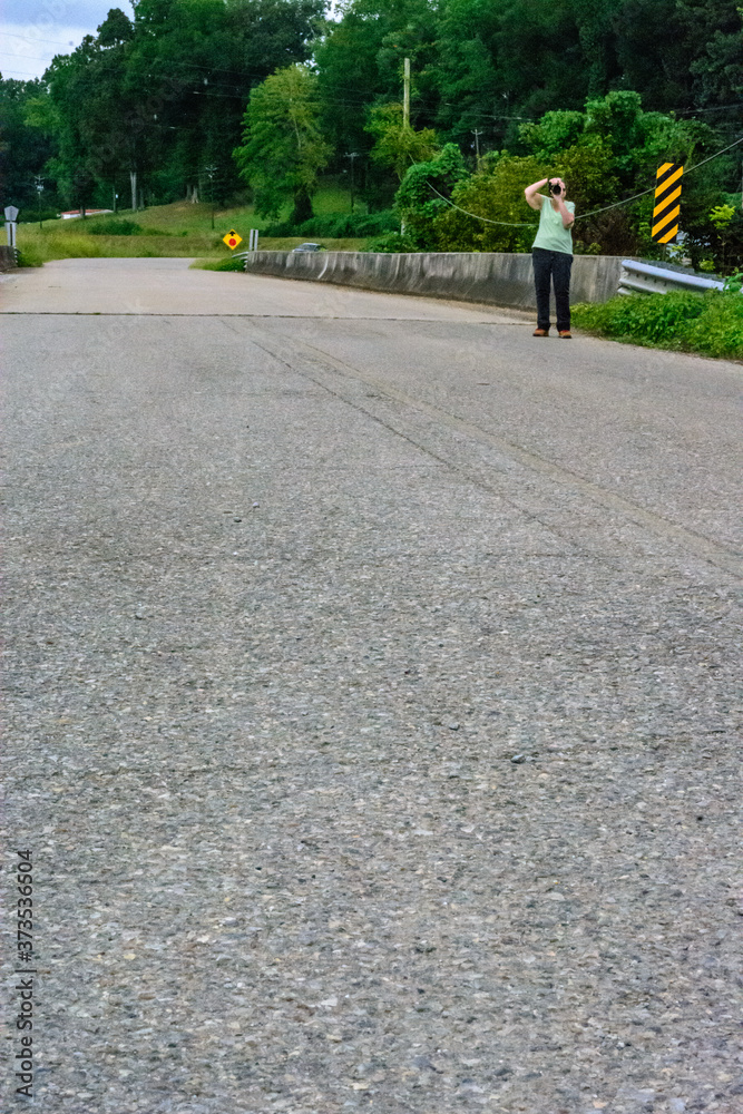 Fototapeta premium woman walking on the road taking photos