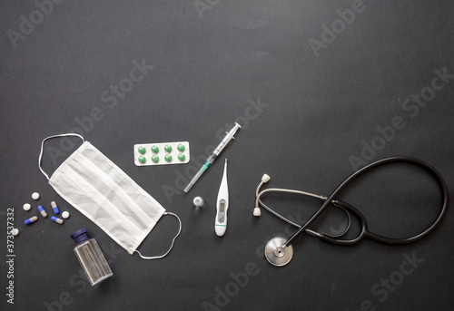 Protective mask, vaccine, COVID 19 diagnosis and prevention medical supplies and tools on black background