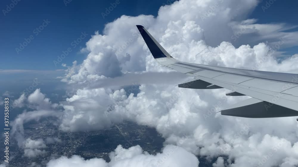 Flying over Miami. View of east coast from plane's window. Beautiful white clouds against blue sky. The turquoise waters of Atlantic coast. Flying over Miami. View of east coast from plane's window. Beautiful white clouds against blue sky. The turquoise waters of Atlantic coast.
