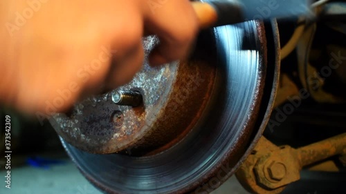 Moving a brake disk by hand and hitting it with a hammer