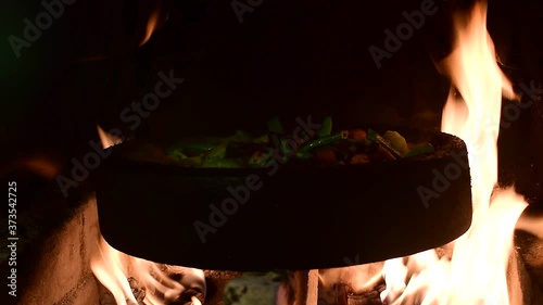 Vegetables cooking on a sach in the fire 