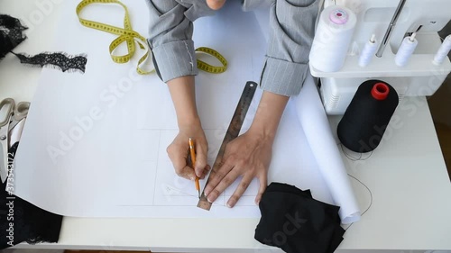 Young woman tailor is designing a new dress in her mini workshop.