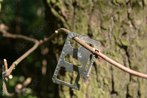 Multi-tool hanging on a tree branch.