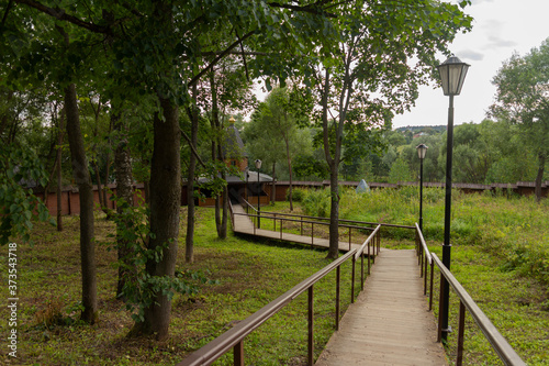 Wooden staircase with railings in the summer forest.
