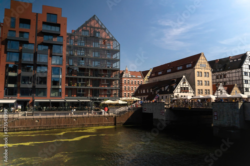 Gdansk, North Poland : People walking dining and riding motor boat in summer in motlawa river adjacent to beautiful european architecture near baltic sea during covid 19 pandemic © Arpan