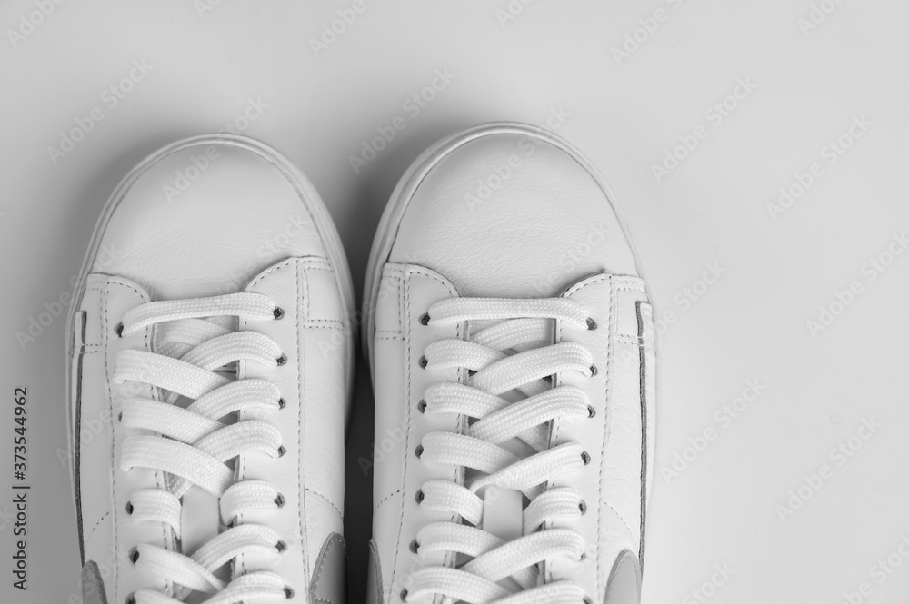 pair of trendy white sneakers on a white background. Top view