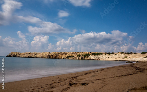 Sandy and pebble beach of the Mediterranean Sea, shot in calm weather at night with a long exposure.