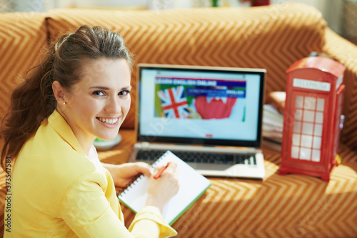 happy woman in modern living room in sunny day learning English