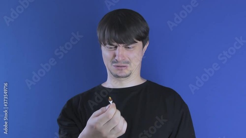 A man cleans his ears with a cotton swab and pulls out earwax