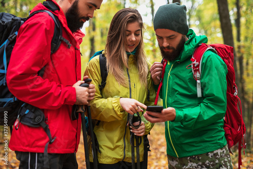 Young travelers examining map on smartphone