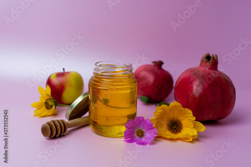 Jar of honey, apples and pomegranates on the table for the holiday of Rosh Hashanah photo