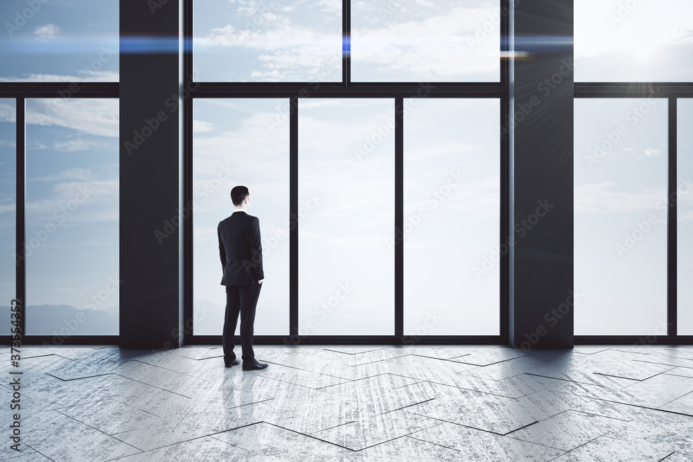 Young businessmen standing in empty concrete hallway interior Young businessmen standing in empty concrete hallway interior