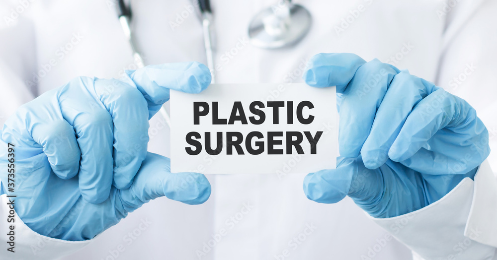 Doctor holding a card with text PLASTIC SURGERY, medical concept Doctor holding a card with text PLASTIC SURGERY, medical concept