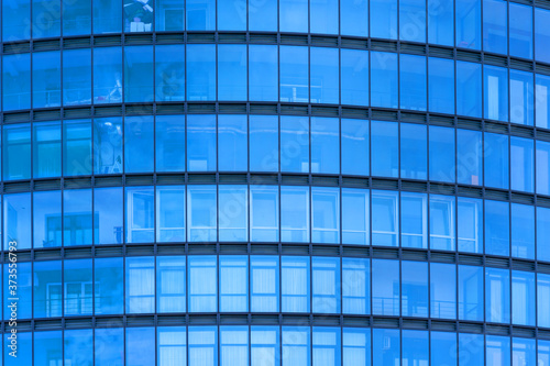 spacious blue glass wall with windows of modern office building business center concept