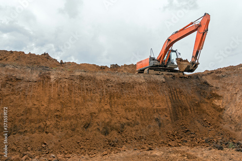 The construction site excavator digs a deep pit. Digger. Construction machinery. Excavation at a construction site