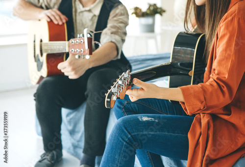 Learning to play the guitar. The teacher explains to the student the basics of playing the guitar. Individual home schooling or extracurricular lessons. photo