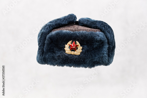 Soviet winter hat with pin badge on light background photo