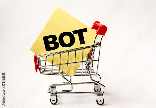 Shopping cart and text bot on white paper note list. Shopping list, business concept on white background.