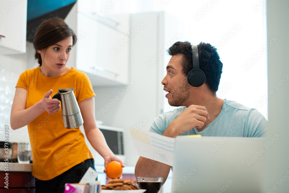 Puzzled woman showing coffee pot to her boyfriend Puzzled woman showing coffee pot to her boyfriend
