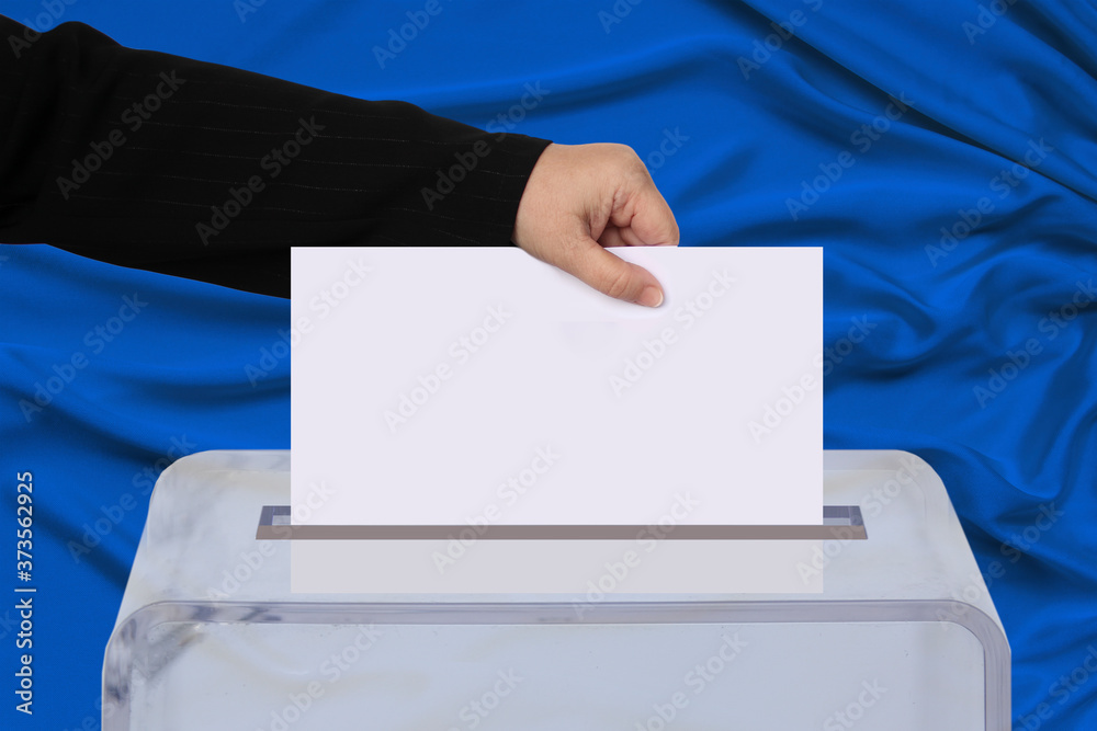 male hand of a voter lowers the ballot in a transparent ballot box on the background, concept of state elections, referendum male hand of a voter lowers the ballot in a transparent ballot box on the background, concept of state elections, referendum
