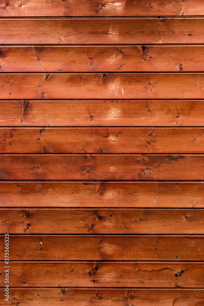 Obraz premium Wooden background for interiors and modern design ideas Treated wooden boards - wood decking flooring and wood deck with paneled walls. Textures and patterns of natural wood. Old brown facade