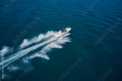 Top view of a white boat sailing in the blue sea. Yachts at the sea surface. Travel - image © Berg