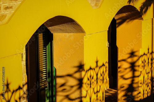 Patterned architectural shadows on a yellow wall.