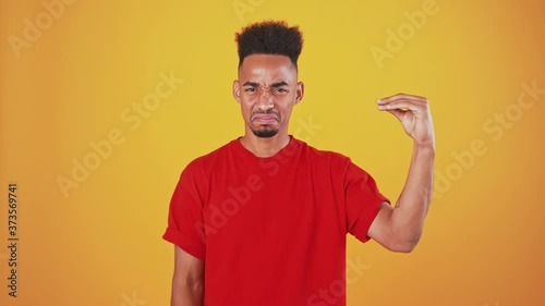 African american man showing bla bla gesture with hand and shaking head no, orange studio background photo