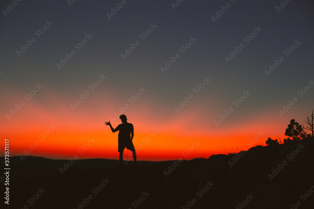Silhouette of a man standing on a mountain top