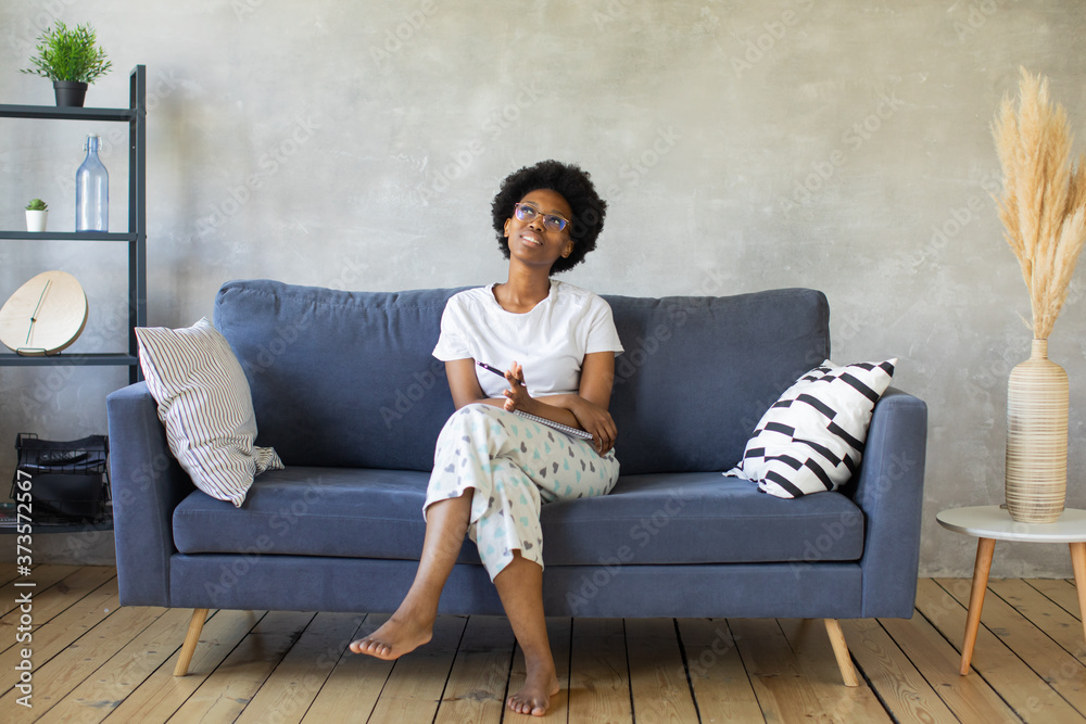 African American girl writes in a notebook in a cozy room African American girl writes in a notebook in a cozy room