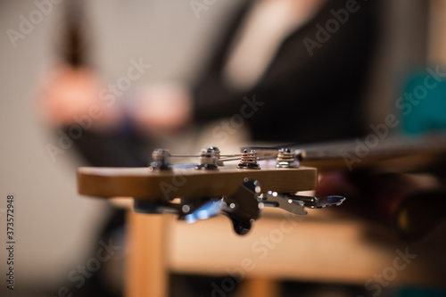 tuning pegs and fretboard bass guitar close up on the background of the musician's apartment with copy space