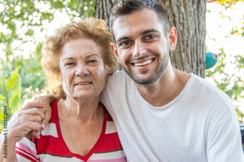 portrait of young man with happy grandmother smiling outdoors portrait of young man with happy grandmother smiling outdoors