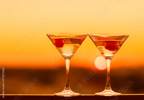 Martini drink at golden sunset background. Night life concept.