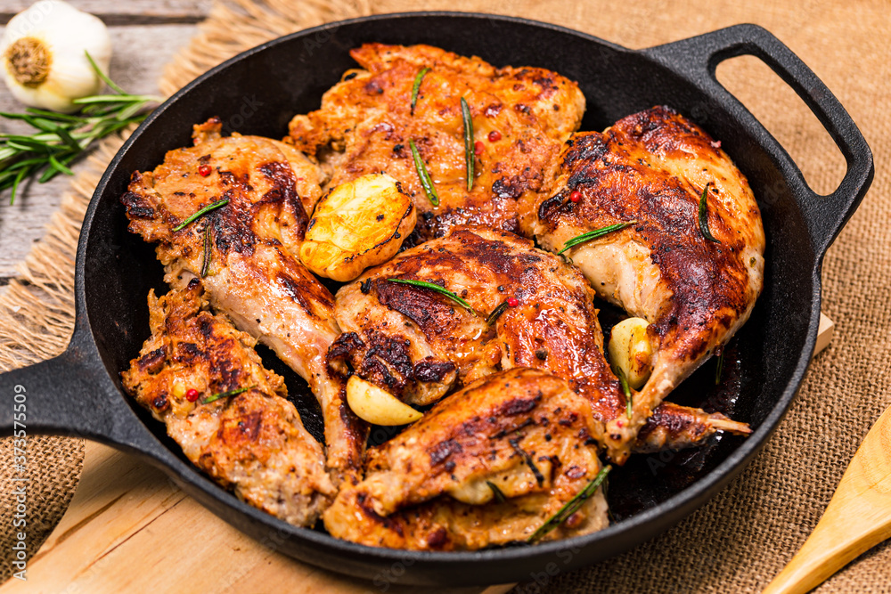 Braised Fried Rabbit with Rosemary, Garlic and Olive Oil on Wooden Background. Selective focus. Braised Fried Rabbit with Rosemary, Garlic and Olive Oil on Wooden Background. Selective focus.