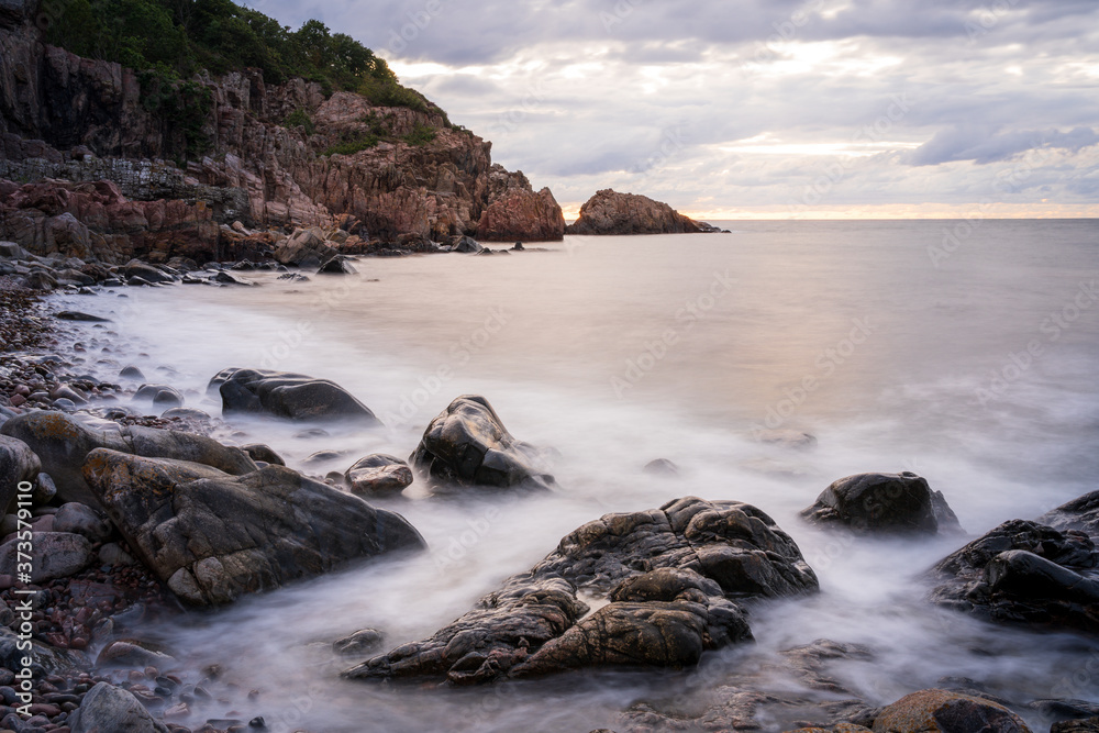 Long exposure on rocky beach during sunset at Kullaberg in Sweden. Long exposure on rocky beach during sunset at Kullaberg in Sweden.