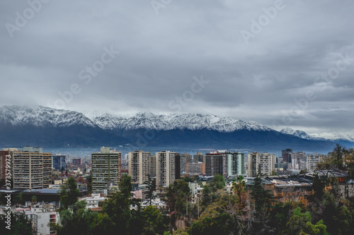 Beautiful clouds and blue sky over Santiago skyline, Santa Lucía hill and the snowed Los Andes mountains, Chile