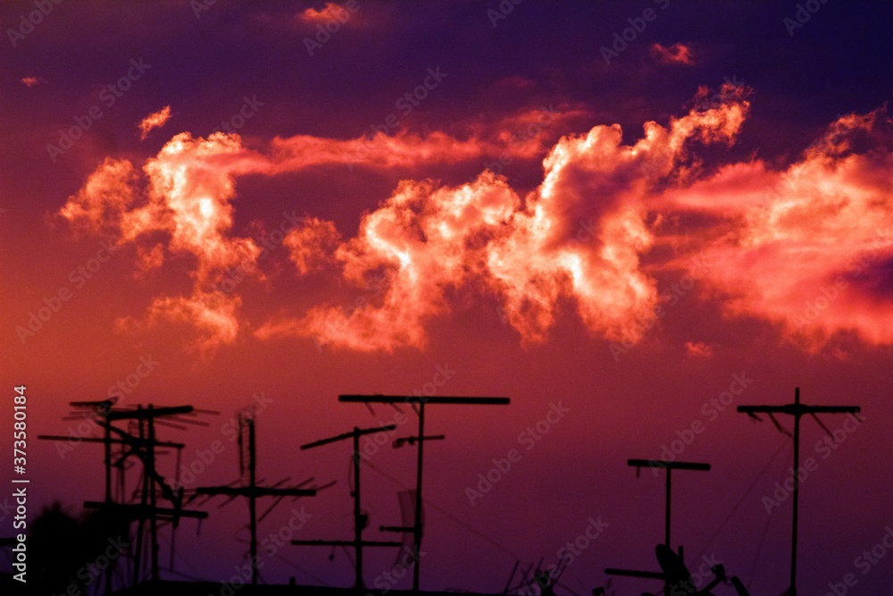 Obraz premium Antenas no telhado e o céu avermelhado