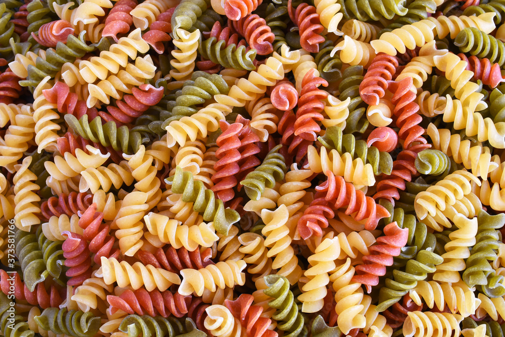A top view image of multi-colored uncooked pasta. A top view image of multi-colored uncooked pasta.