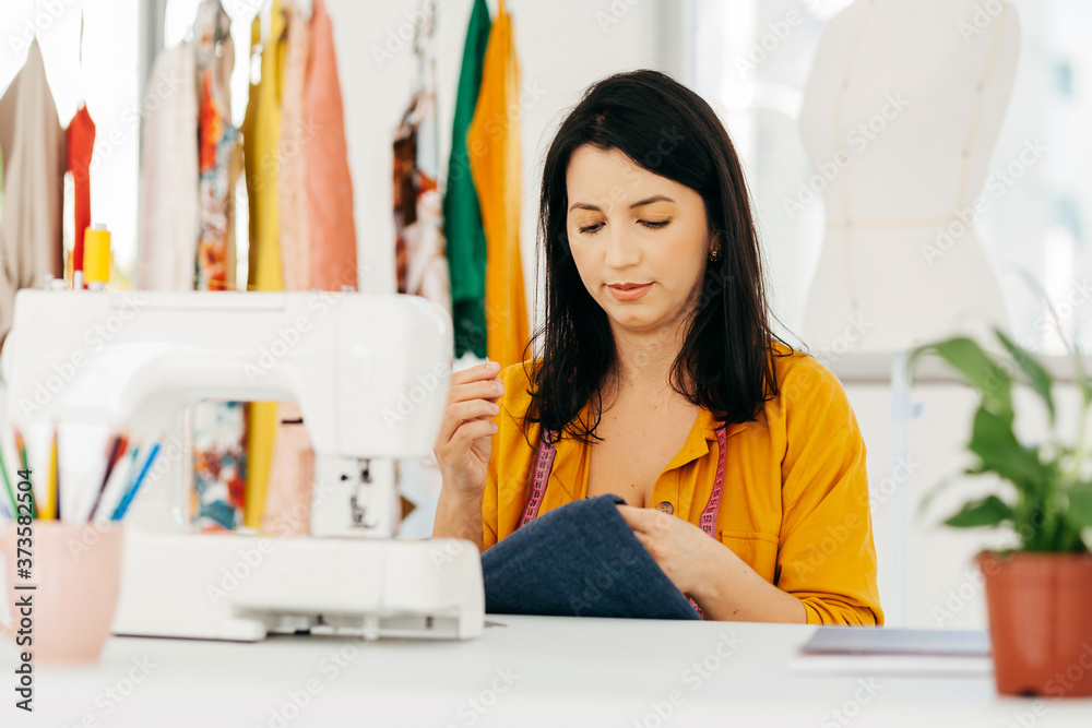 Seamstress working at her workplace. Latin woman owner of small business. Seamstress working at her workplace. Latin woman owner of small business.