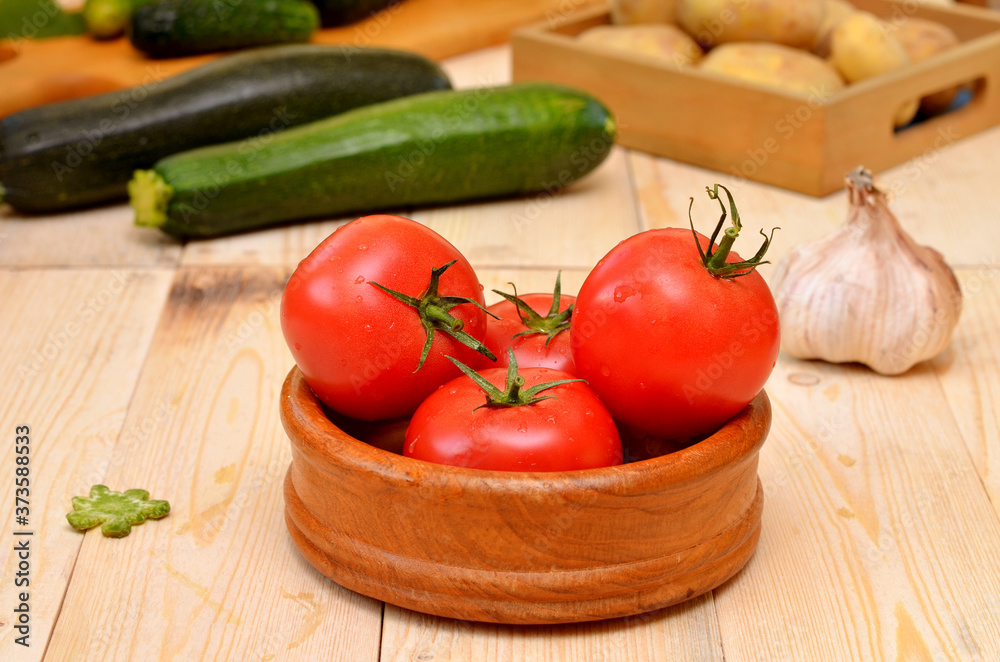 bowl with tomatoes and assorted fresh vegetables on the kitchen table